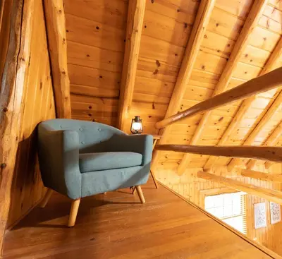 a blue chair in a room with wooden ceilings at Athens and Albany's Hillside Haven in Albany