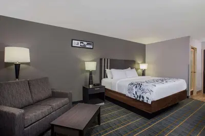 a hotel room with a bed and a couch at Baymont by Wyndham Lancaster in Lancaster