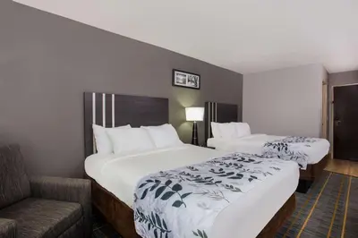 a hotel room with two beds and a couch at Baymont by Wyndham Lancaster in Lancaster