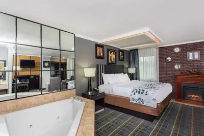 a hotel room with a bed and a bath tub at Baymont by Wyndham Lancaster in Lancaster
