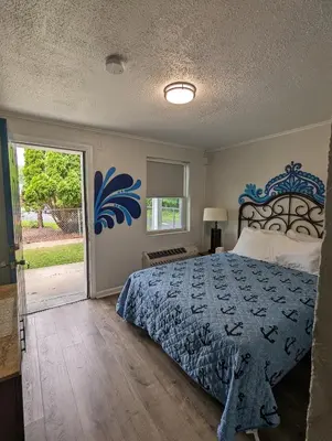 a bedroom with a bed and a sliding glass door at Riverboat Inn & Suites in Madison