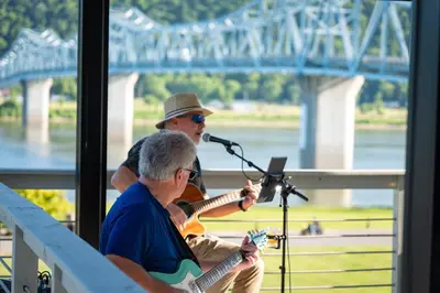 a man playing a guitar and a man playing a microphone at Riverboat Inn & Suites in Madison