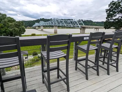 a row of chairs sitting on a deck with a bridge at Riverboat Inn & Suites in Madison