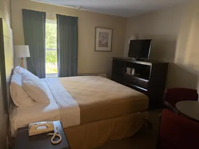 a hotel room with a bed and a television at Clinton Inn & Suites in Port Clinton