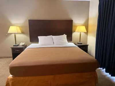 a bed in a hotel room with two lamps at Clinton Inn & Suites in Port Clinton