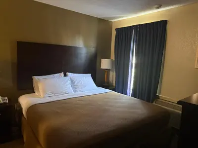 a hotel room with a large bed with white pillows at Clinton Inn & Suites in Port Clinton