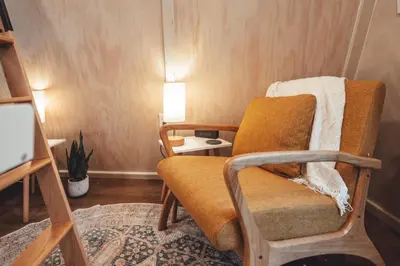 a living room with a chair and a table at Blue Brambler Glamping A-Frame in Rockbridge