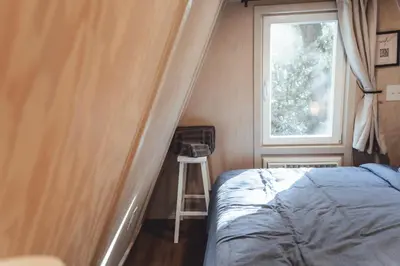 a small bedroom with a bed and a window at Blue Brambler Glamping A-Frame in Rockbridge