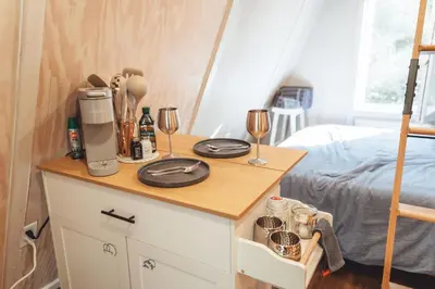 a room with a bed and a table with wine glasses at Blue Brambler Glamping A-Frame in Rockbridge