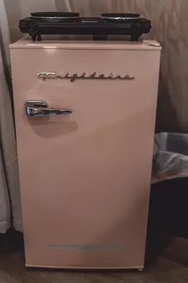 a small white refrigerator with a black top at Blue Brambler Glamping A-Frame in Rockbridge