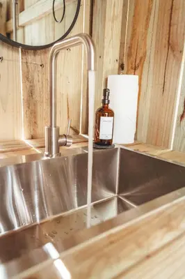 a bottle of soap sitting on a kitchen sink at Blue Brambler Glamping A-Frame in Rockbridge