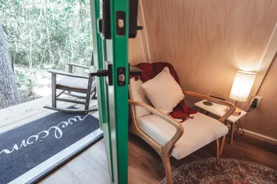 a living room with a chair and a table at The Green Glamping Getaway in Rockbridge