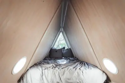 a small bed in a tent with two windows at The Green Glamping Getaway in Rockbridge