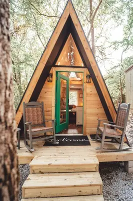a tiny house with two chairs and a green door at The Green Glamping Getaway in Rockbridge