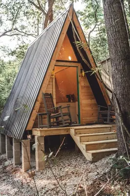 a cabin in the woods with a porch and a roof at The Green Glamping Getaway in Rockbridge