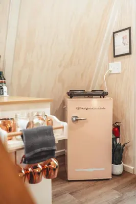 a room with a chair and a refrigerator at The Green Glamping Getaway in Rockbridge