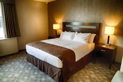 a hotel room with a large bed and two lamps at DoubleTree by Hilton Lawrenceburg in Lawrenceburg