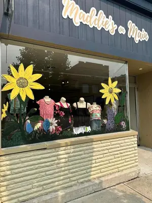 a store window with a display of dresses and flowers at The Baker The Archive Lofts in Marion
