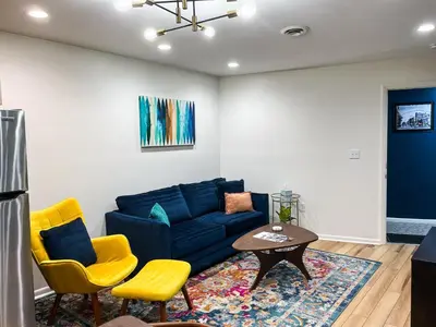 a living room with a blue couch and yellow chairs at The True The Archive Lofts in Marion