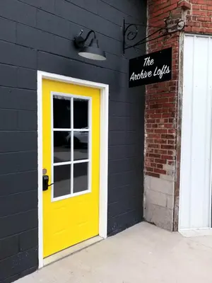 a yellow door on the side of a building at The True The Archive Lofts in Marion