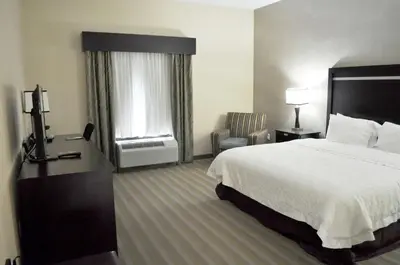 a hotel room with a bed and a chair at Hampton Inn & Suites Toledo/Westgate in Toledo