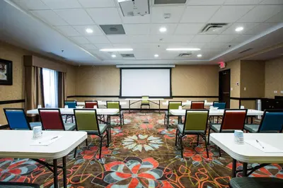 a conference room with tables and chairs and a projection screen at Hampton Inn & Suites Toledo/Westgate in Toledo