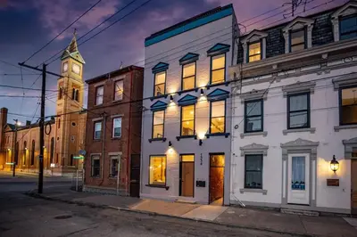 a building on a city street with a clock tower at Cozy Apartment in Historic OTR in Cincinnati