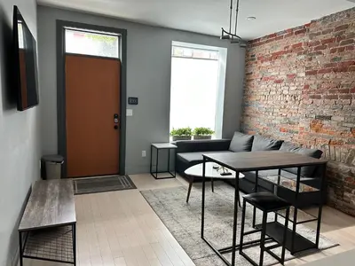 a living room with a couch and a brick wall at Cozy Apartment in Historic OTR in Cincinnati