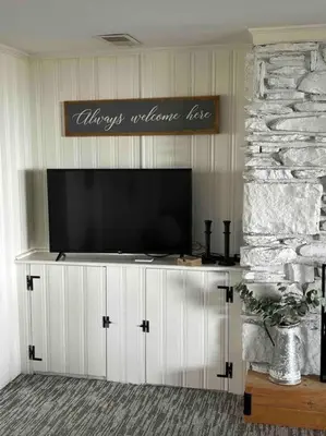 a flat screen tv sitting on top of a entertainment center at Lakeside Oasis/Golf Cart/Beach in Luna Pier