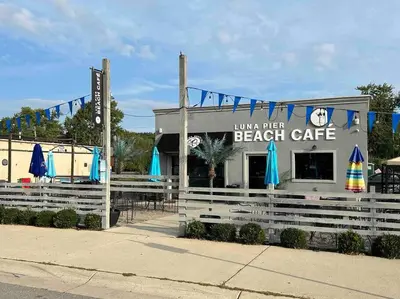 a beach cafe with blue umbrellas in front of it at Lakeside Oasis/Golf Cart/Beach in Luna Pier