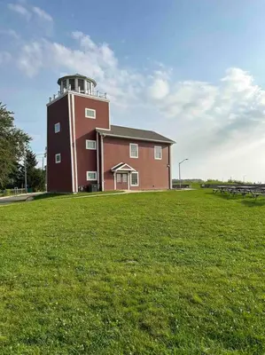 a building with a tower on top of a grass field at Lakeside Oasis/Golf Cart/Beach in Luna Pier