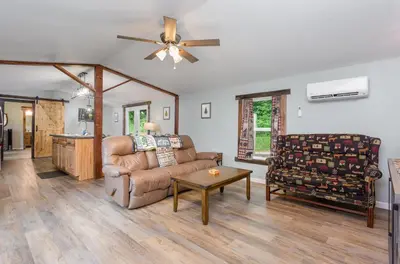 a living room with a couch and a table at Grey Pines at Hocking Vacations in Logan