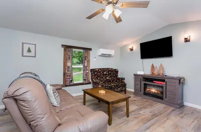 a living room with a couch and a fireplace at Grey Pines at Hocking Vacations in Logan