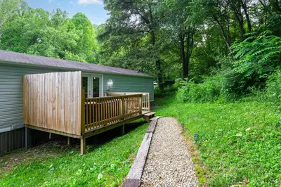 a house with a deck on the side of it at Grey Pines at Hocking Vacations in Logan