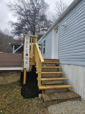 a wooden staircase leading to a house with a sign at Grey Pines at Hocking Vacations in Logan