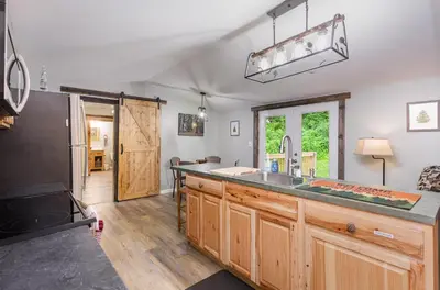 a kitchen with a sink and a refrigerator at Grey Pines at Hocking Vacations in Logan