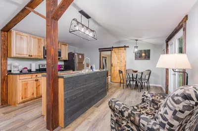 a kitchen and living room with a couch and chairs at Grey Pines at Hocking Vacations in Logan
