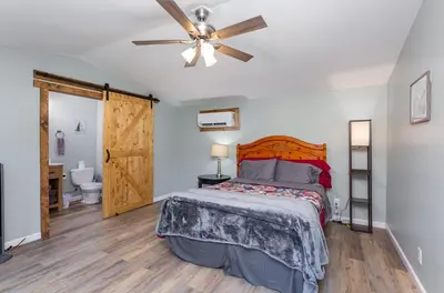 a bedroom with a bed and a ceiling fan at Grey Pines at Hocking Vacations in Logan