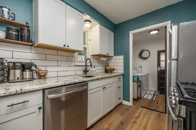 a kitchen with white cabinets and blue walls at Close to airport* Pets*Fenced yard*A/C & Fast WIFI in Cleveland