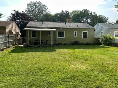 a green house with a yard with a fence at Close to airport* Pets*Fenced yard*A/C & Fast WIFI in Cleveland