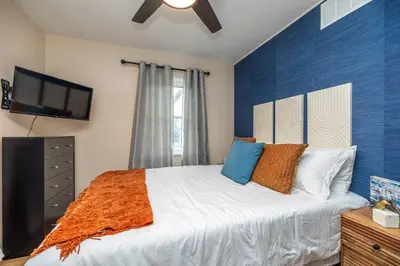a bedroom with a large bed and a flat screen tv at Close to airport* Pets*Fenced yard*A/C & Fast WIFI in Cleveland
