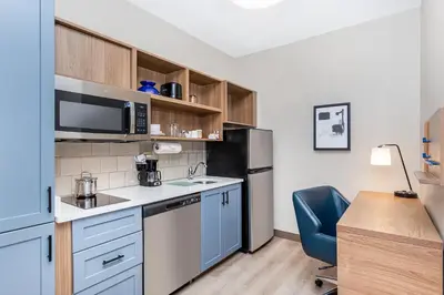 a small kitchen with a sink and a refrigerator at Candlewood Suites Erlanger - South Cincinnati by IHG in Erlanger