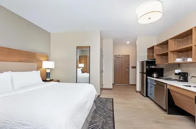 a hotel room with a bed and a kitchen at Candlewood Suites Erlanger - South Cincinnati by IHG in Erlanger