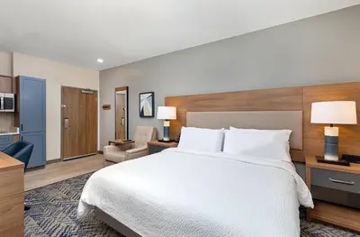 a hotel room with a bed and a chair at Candlewood Suites Erlanger - South Cincinnati by IHG in Erlanger