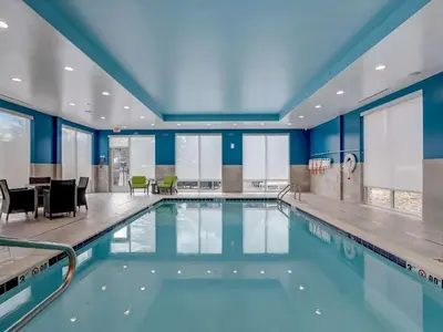 a swimming pool in a building with blue walls at Hampton Inn & Suites Cincinnati Midtown Rookwood in Cincinnati