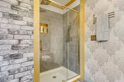 a bathroom with a shower with a glass door at Historic Auburn Home with Theater and Yard! in Auburn