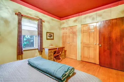 a bedroom with a bed and a desk and a window at Historic Auburn Home with Theater and Yard! in Auburn