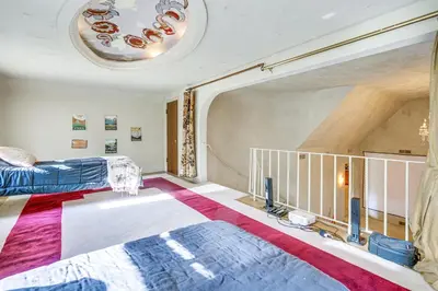 a bedroom with two beds and a balcony at Historic Auburn Home with Theater and Yard! in Auburn