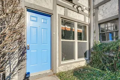 a blue door on a house with a window at Historic Auburn Home with Theater and Yard! in Auburn