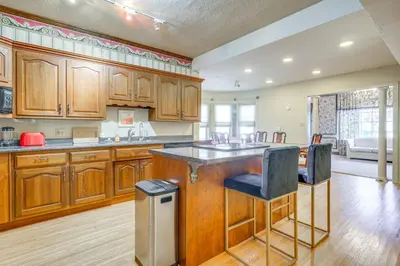 a large kitchen with wooden cabinets and a counter top at Historic Auburn Home with Theater and Yard! in Auburn